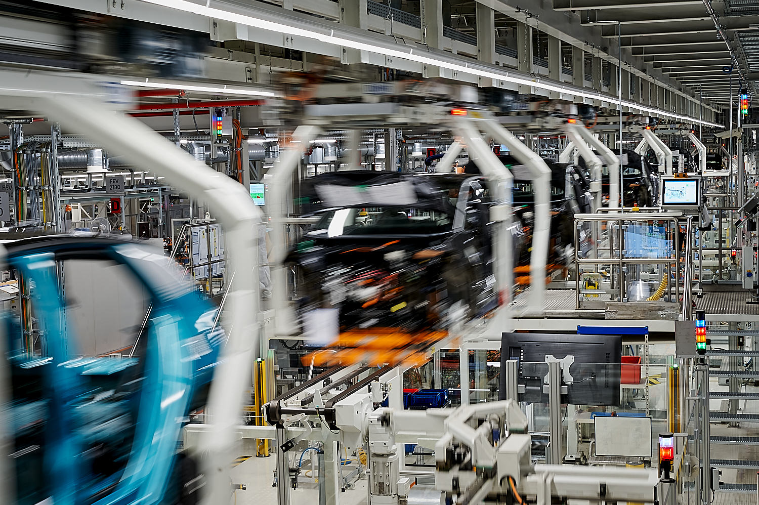 Automotive final assembly line with robotic systems and vehicle body in motion